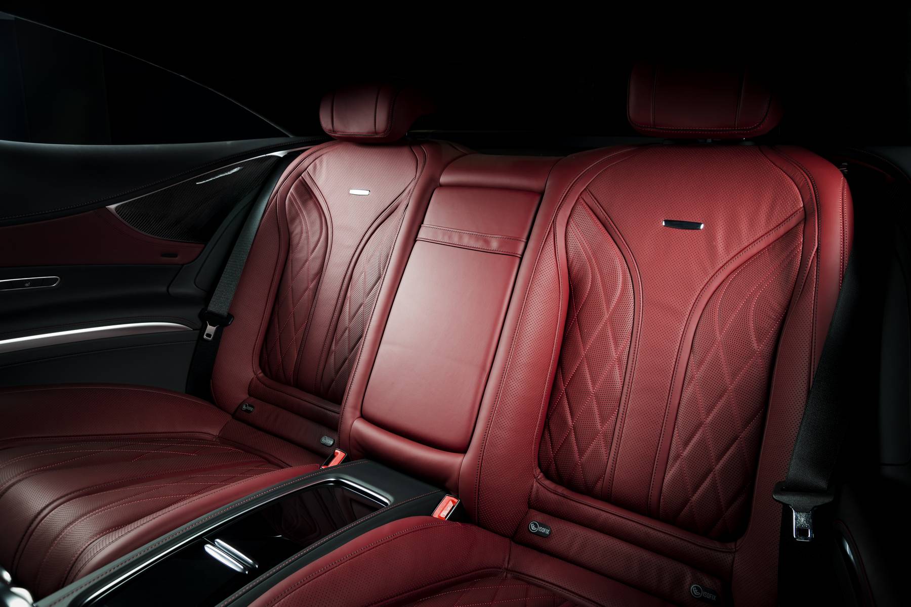Back passenger seats in modern luxury car, frontal view, red leather