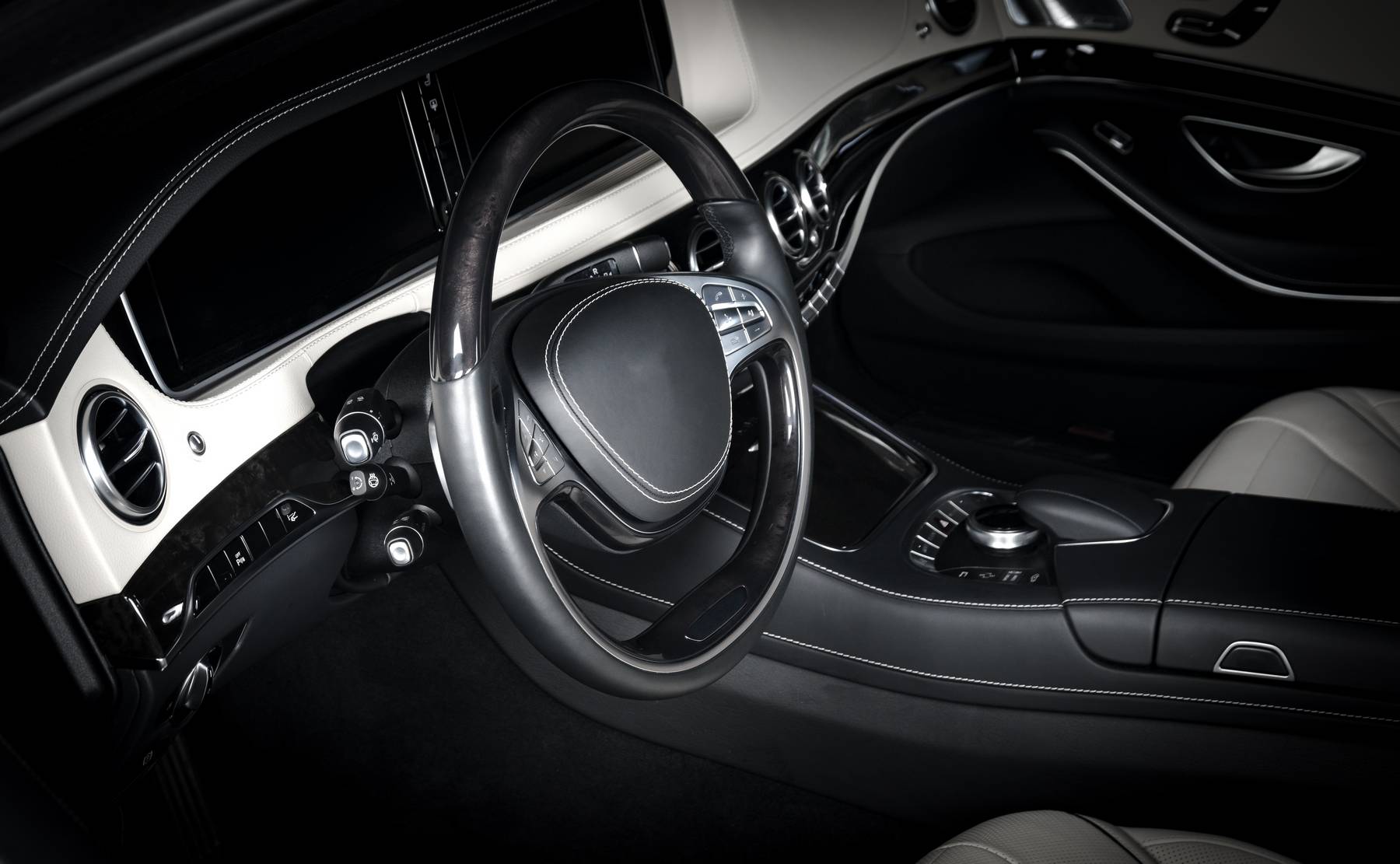 Modern luxury prestige car interior, dashboard, steering wheel. Black and white leather interior. Isolated windows, clipping path included